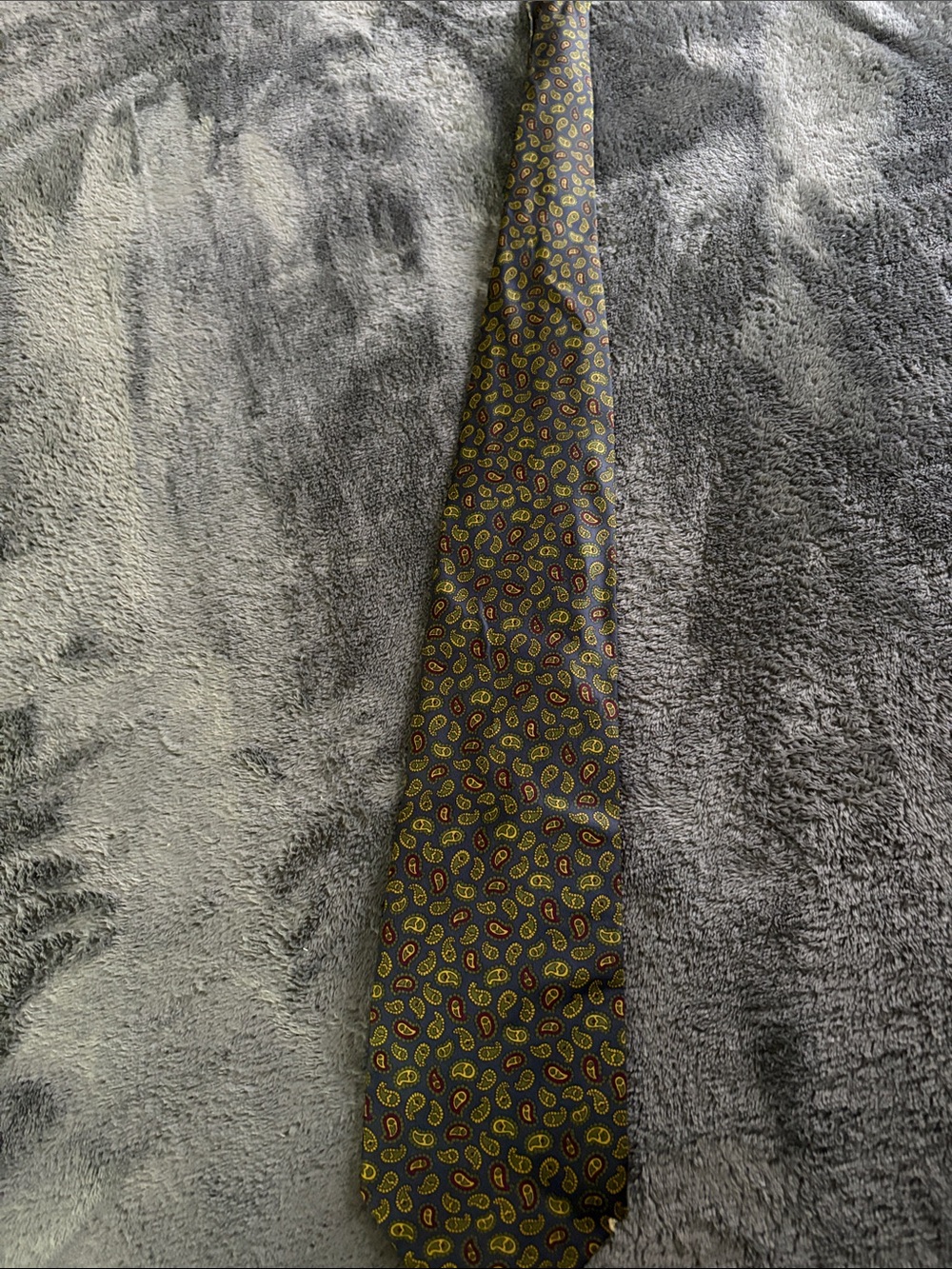 Men's Paisley Neck Tie in Navy with Yellow and Red Accents has a small flaw .
